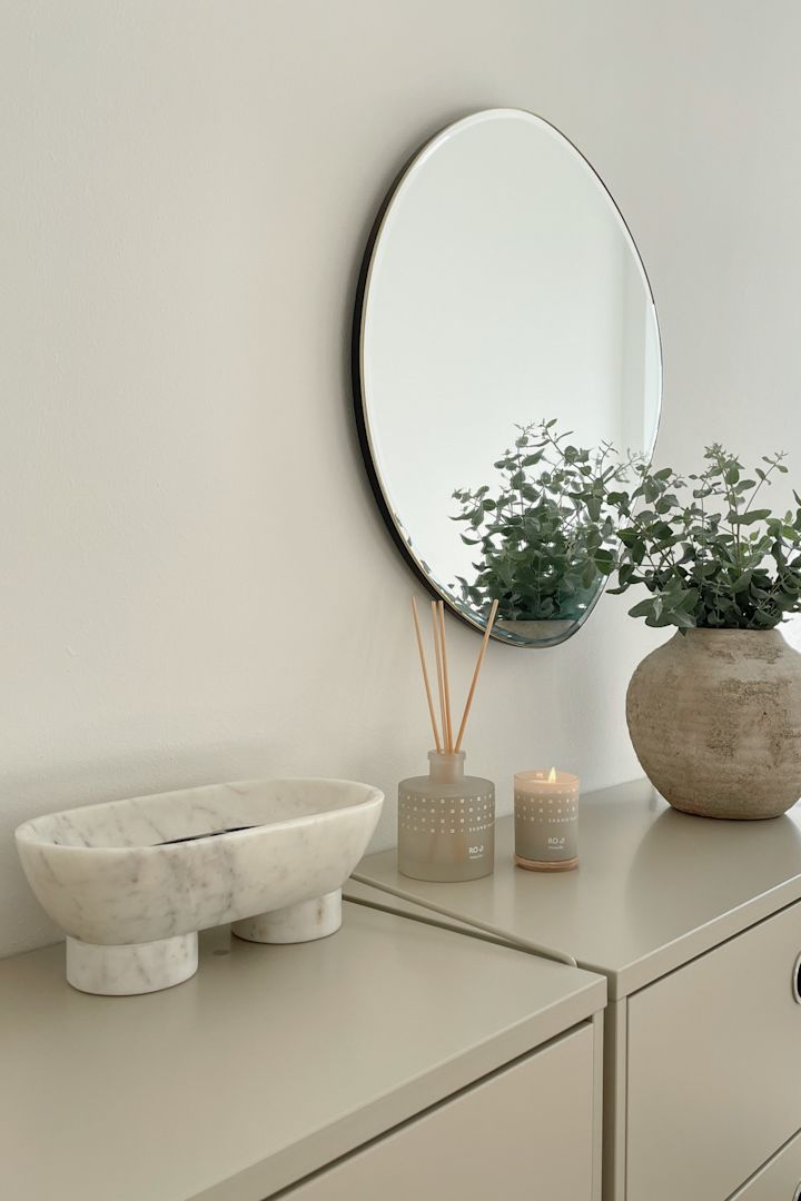 Natural materials such as the Alza bowl in marble from Ferm living and scented candles and diffusers from Skandinavisk add a luxurious touch to a Scandinavian style bedroom. 